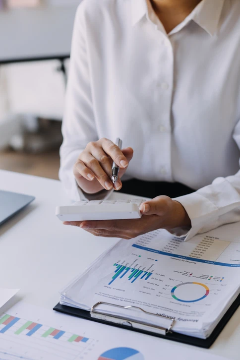 Deux professionnels en costume analysent des documents financiers sur une table de réunion