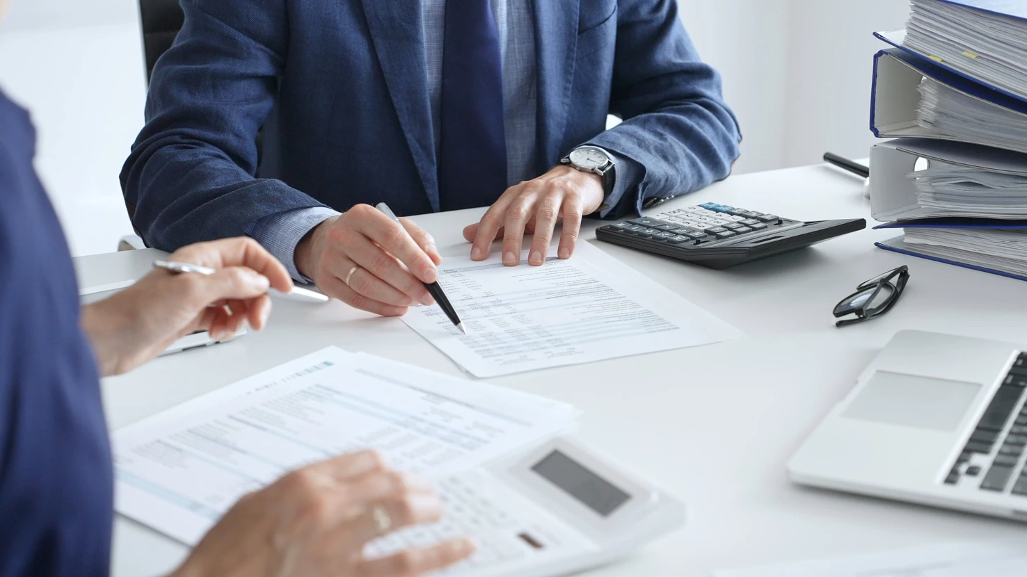 Réunion d'affaires en intérieur avec deux professionnels analysant des données financières