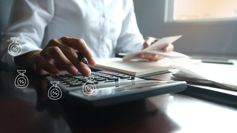 Une femme en chemise blanche travaille à un bureau en remplissant des formulaires avec un stylo